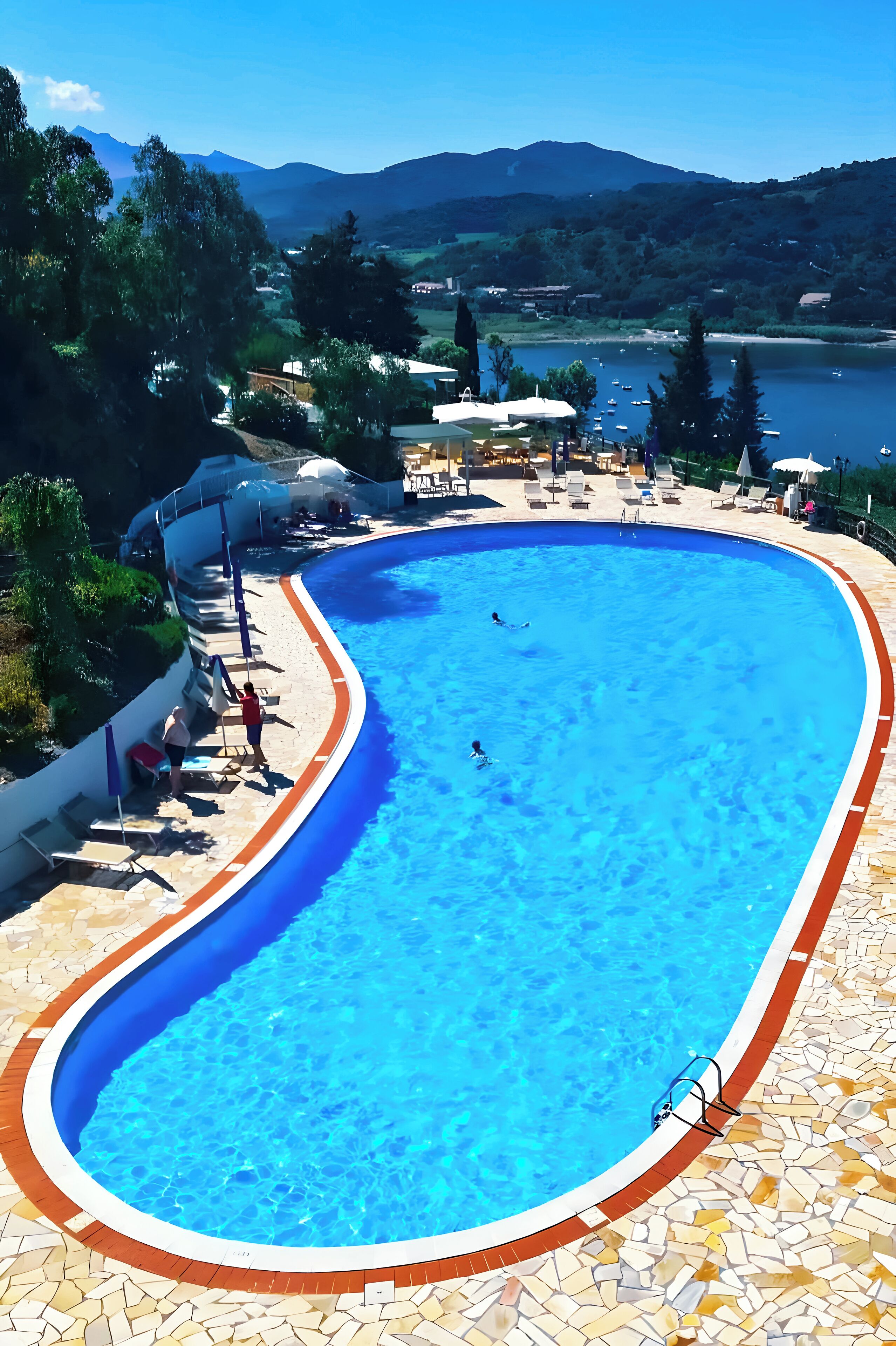 Een buitenzwembad, parasols voor strand/zwembad