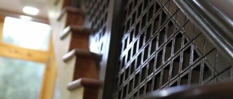 A close-up of a metal staircase with a grid-like pattern.