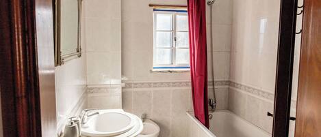 Une salle de bain avec un lavabo, des toilettes et une baignoire.