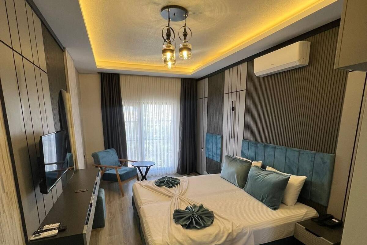 Una moderna camera d'albergo con un letto grande, una scrivania, una sedia, una TV e un condizionatore.