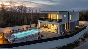 A modern two-story house with a swimming pool, outdoor seating, and a balcony. - Villa Merci Zadar Villas (Privlaka)