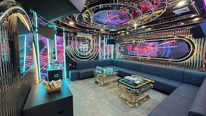 A luxurious interior with a curved ceiling, reflective surfaces, and modern seating areas. - Paloma Hotel (Van Don)