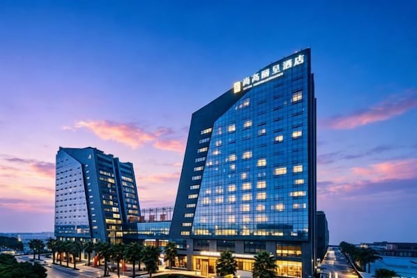 Een modern hotelgebouw met een opvallende glazen gevel en meerdere verdiepingen.