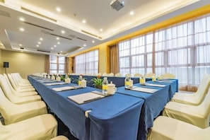 Une salle de conférence équipée d’une longue table, de chaises et d’un projecteur.