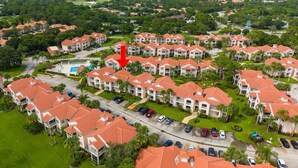 A residential area with multiple apartment buildings, a swimming pool, and a golf course in the background. - Right Direction Rentals Studio Villa 9955 (Port St. Lucie)
