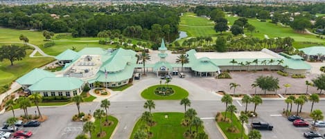 Un campo de golf con un club, zona de estacionamiento y vegetación circundante.