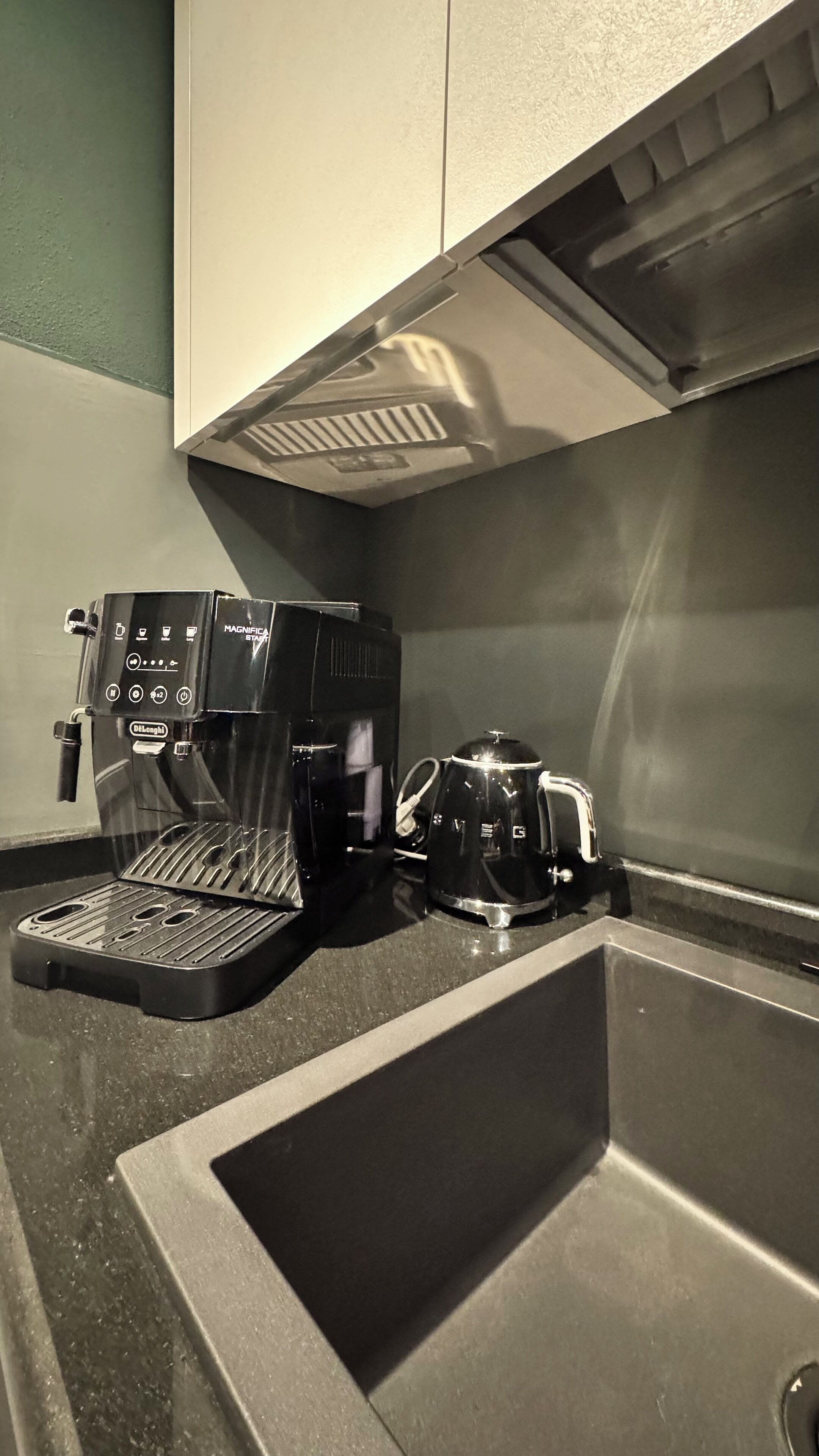 Une cuisine équipée d’une machine à café, d’une bouilloire et d’un évier.