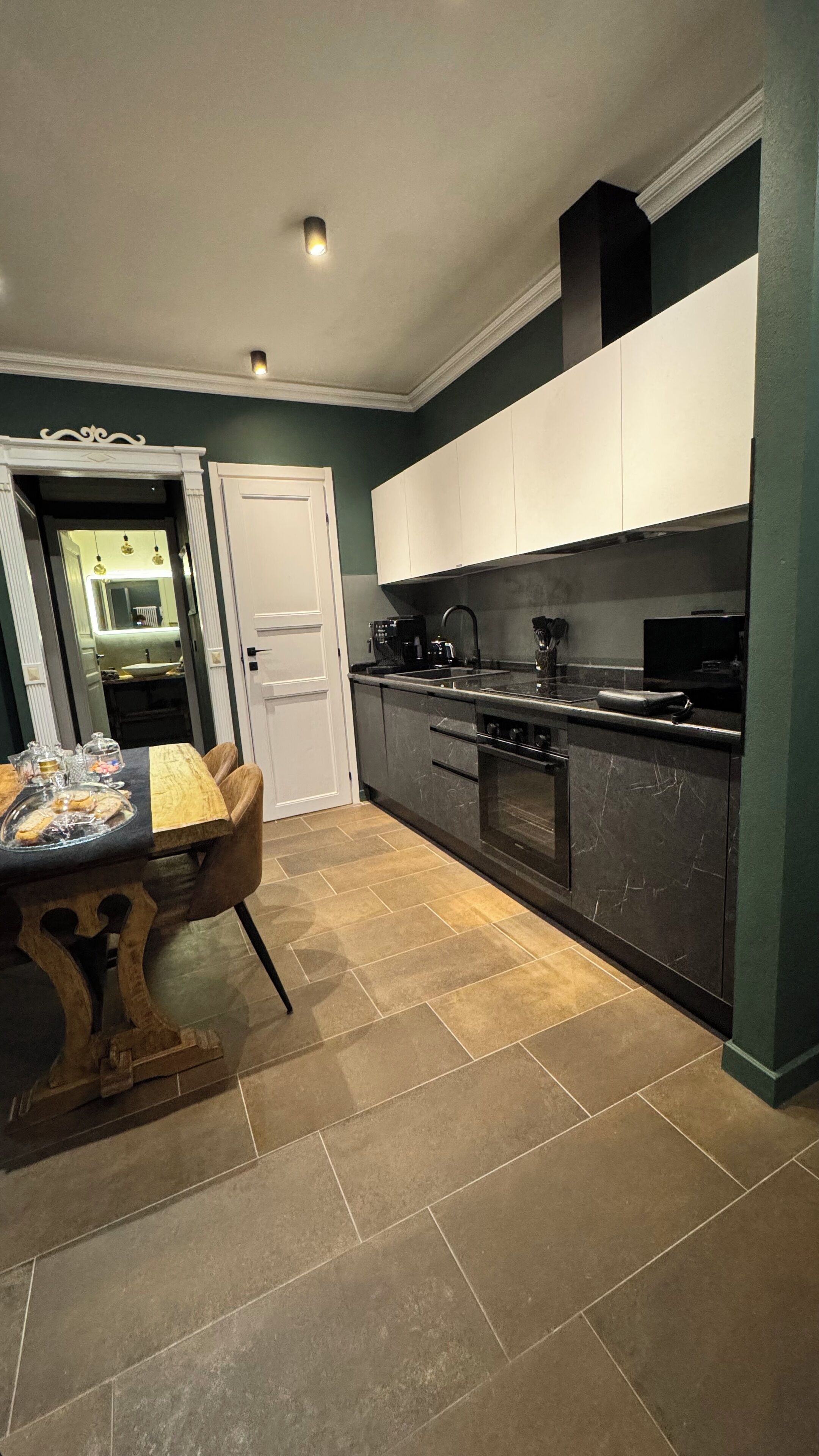 A compact kitchen with dark cabinets, a central island, and a dining area with a table and chairs.