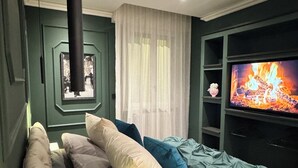 A bedroom with a bed, a TV, and a fireplace. - Mentore Maison Prestige  (Noceto)