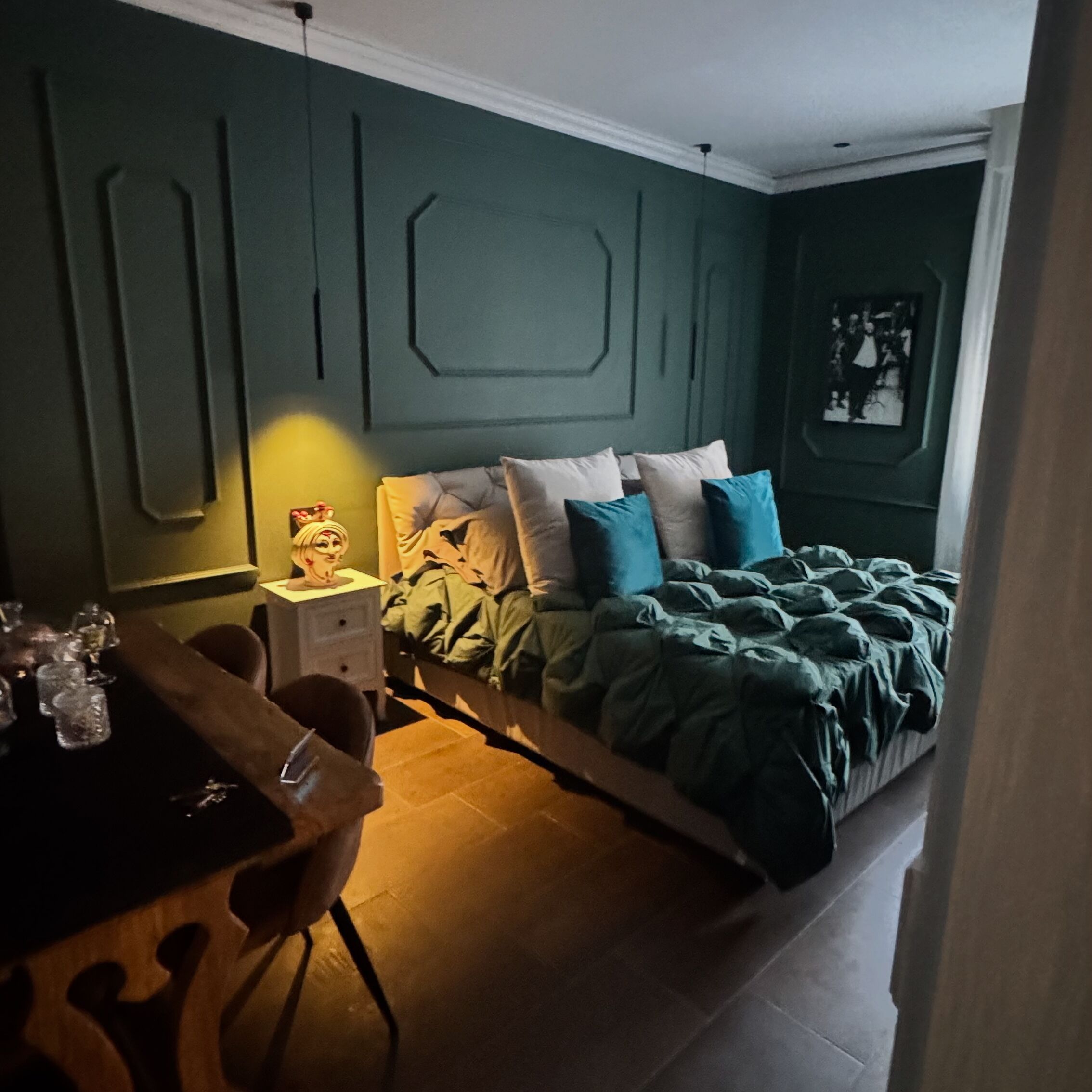A bedroom with a bed, a desk, and a chair.