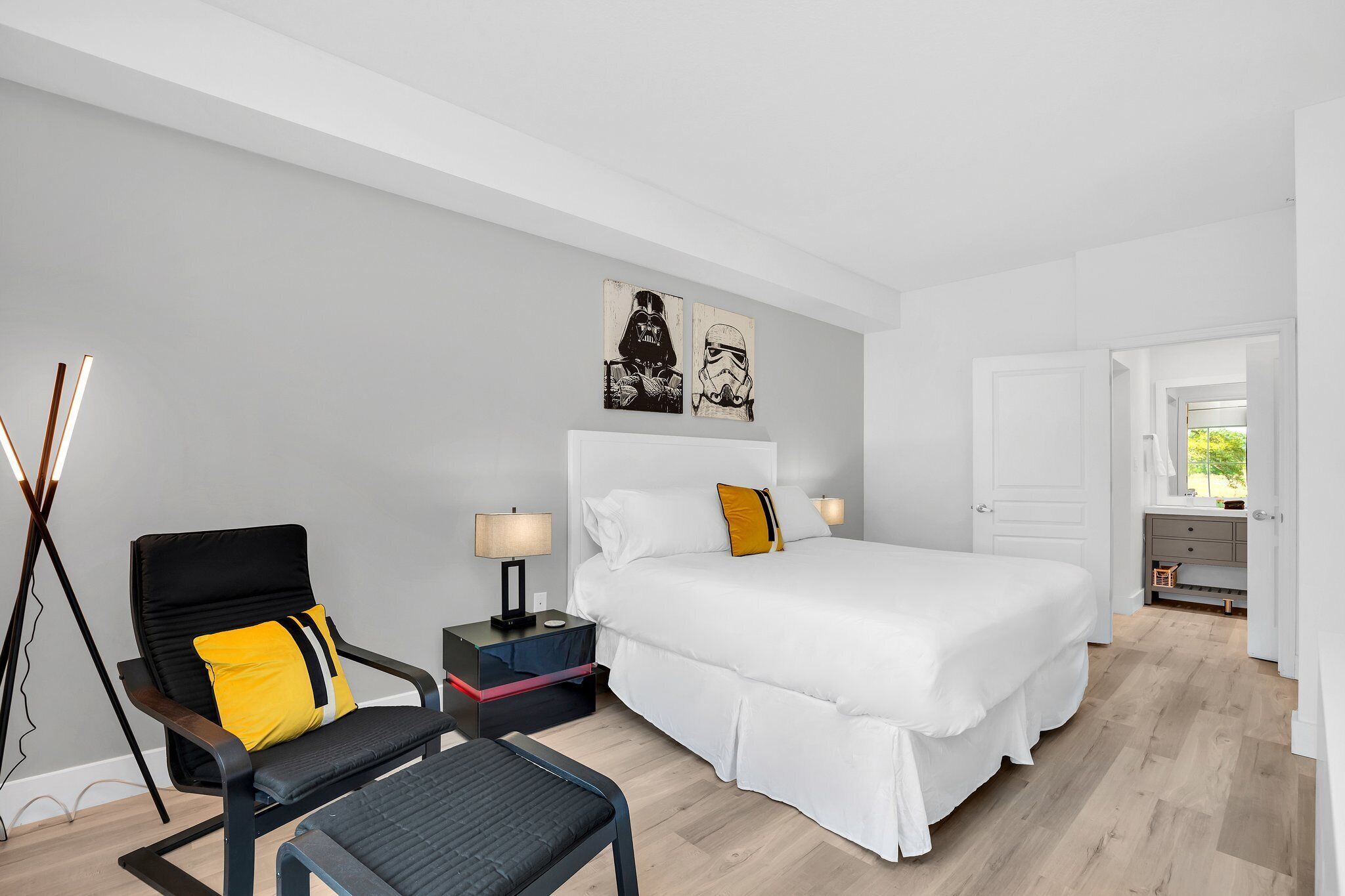 Une chambre d’hôtel moderne avec un grand lit, une table de chevet, une chaise et un bureau.