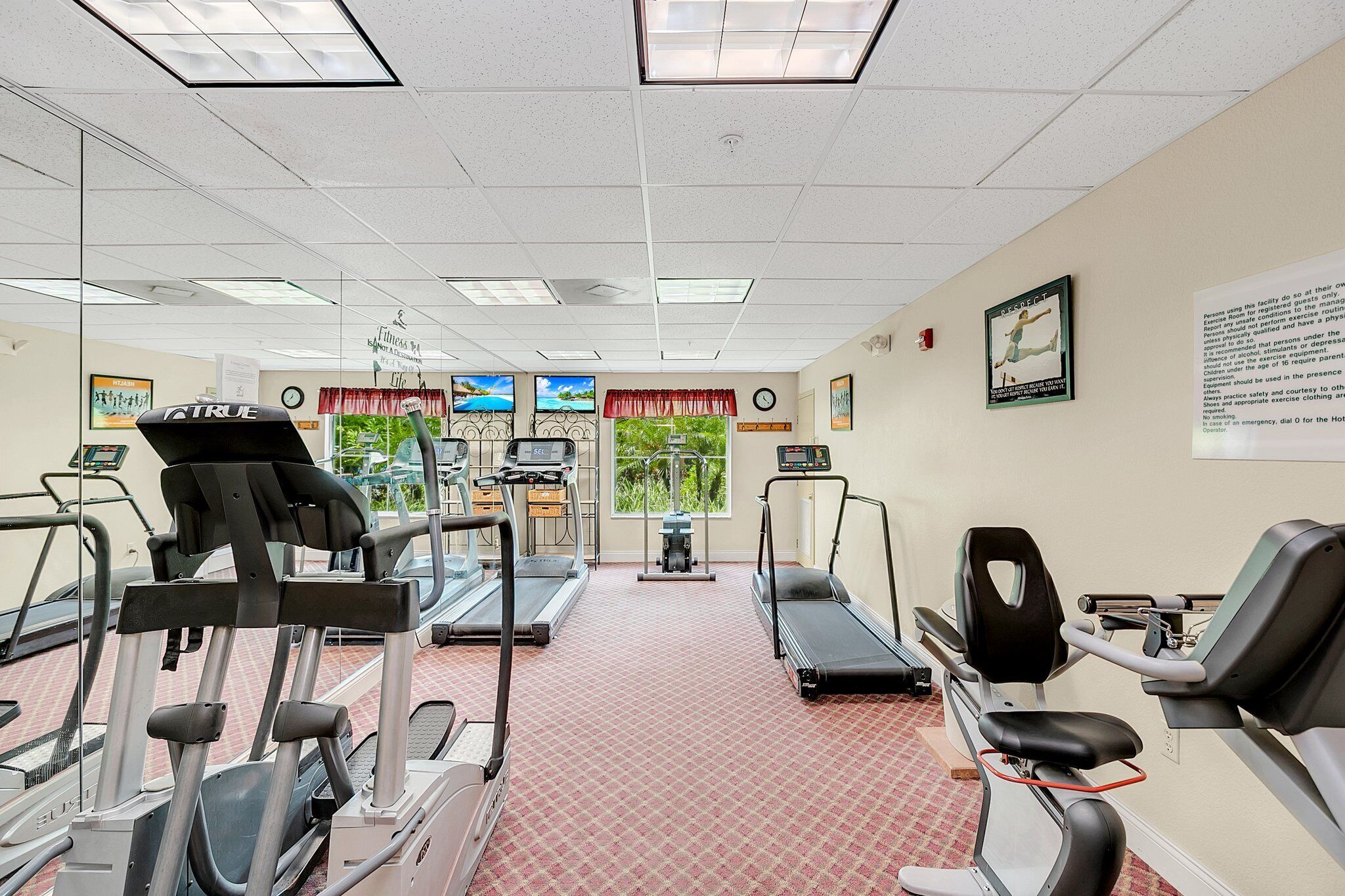 A fitness center with treadmills, elliptical machines, and a stationary bike.