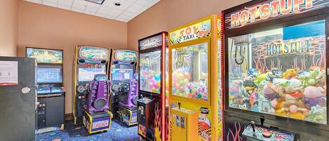 A row of arcade machines including 'Hot Stuff' and 'Toy Taxi' in a room with a patterned carpet.