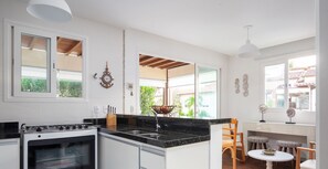 Uma cozinha com fogão, pia e vista para o exterior.