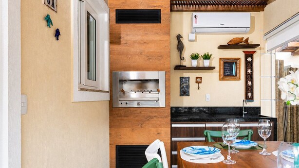 Una cocina con horno empotrado, una ventana y un aire acondicionado de pared.
