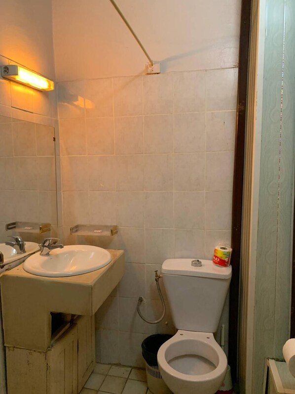 A small bathroom with a sink, toilet, and shower.