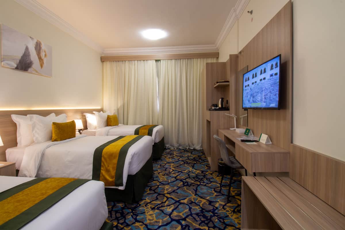Une chambre d’hôtel avec deux lits, un bureau, une télévision et une salle de bain.