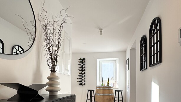 A modern kitchen with a dark wooden cabinet, a round wooden barrel, and a woven rug. - WeinZeit13 (Neustadt an der Weinstraße)