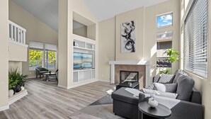 A modern living room with a fireplace, a sofa, a TV, and a dining area. - “NEW” Half Moon Retreat / +Pool Table / - 5 min away from GRATON casino (Santa Rosa)
