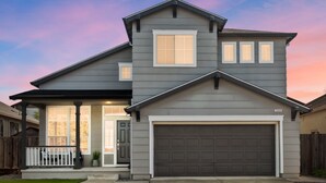 A two-story house with a garage, a covered porch, and a well-maintained lawn. - “NEW” Half Moon Retreat / +Pool Table / - 5 min away from GRATON casino (Santa Rosa)