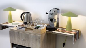 A small kitchenette with a coffee maker, kettle, and a tray with cups and a box of tea. - Sun&City Naples (Naples)