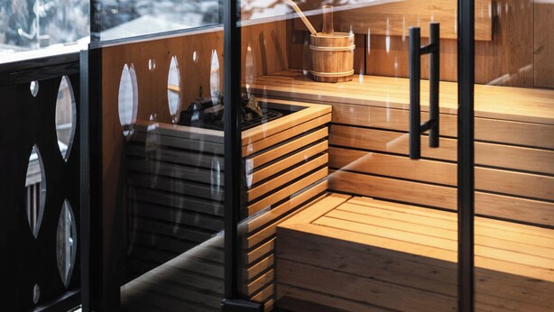 A modern wooden deck with a glass wall offering a mountain view. - DISTINCTIVE LUXURY DOLOMITI APARTMENTS TERRE71 (Marebbe)
