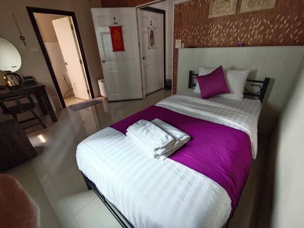 A hotel room with a bed, a desk, and a chair. There is a door with a red sign on it. - TC House And Cafe (Chiang Mai)