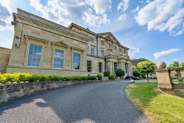A large, historic building with a symmetrical facade, large windows, and a central entrance.