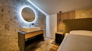 Ein modernes Badezimmer mit einem großen Spiegel, einem rechteckigen Waschbecken und einer Holzausstattung.