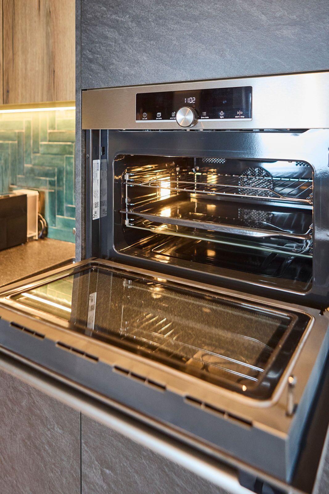 A modern kitchen with a built-in oven and a digital control panel.