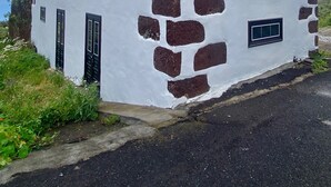 A white building with a stone facade and multiple windows. - El Lomito - Elegant Countryside Home, El Hierro (Villa de Valverde)