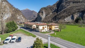 A building with a parking lot and a road in a mountainous area. - La grande Valsassina - Loft (Pasturo)
