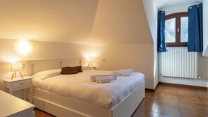 A bedroom with a bed, bedside tables, and a window with curtains. - La grande Valsassina - Loft (Pasturo)