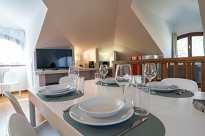 A dining area with a table set for four, including plates, glasses, and cutlery.