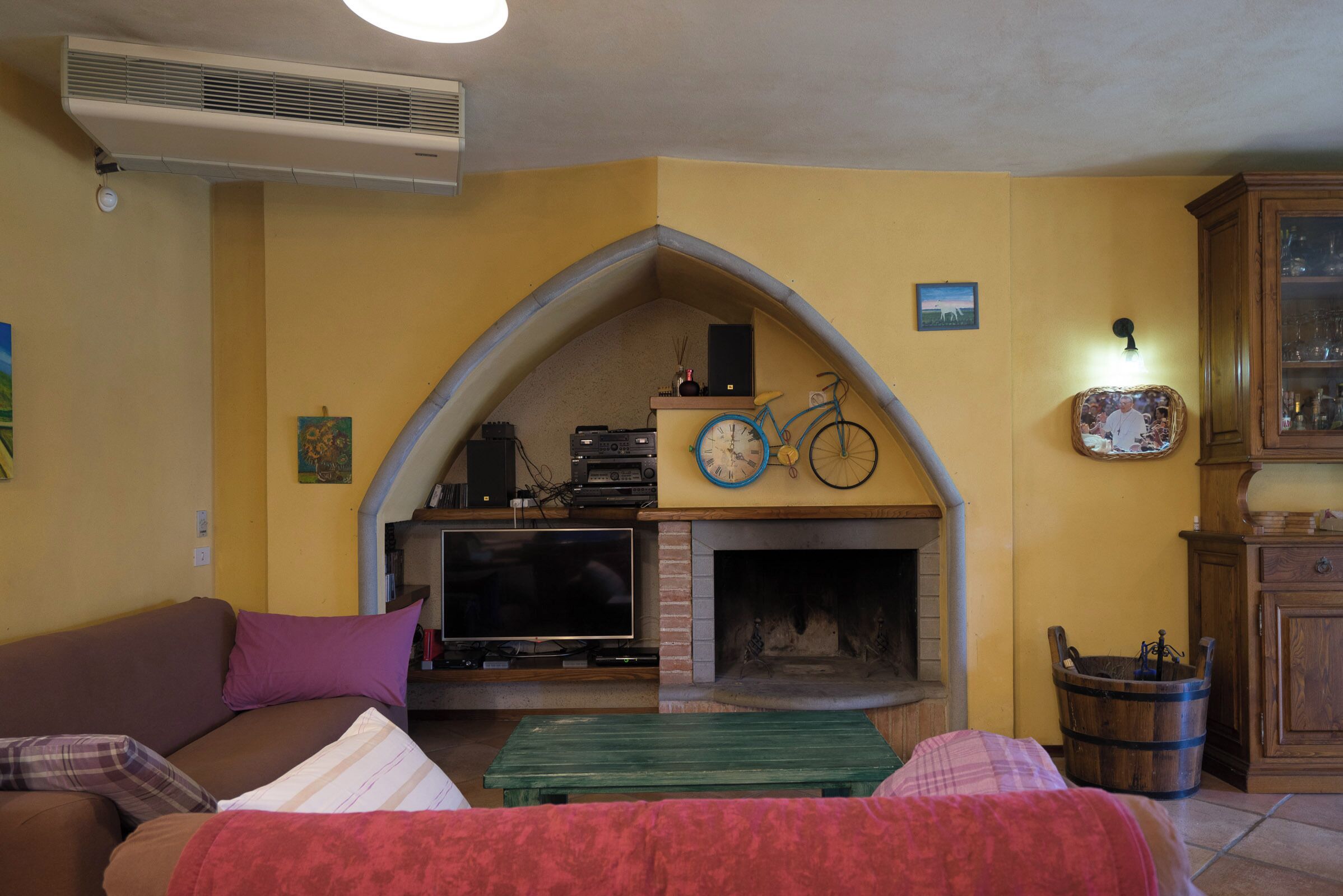 A living room with a fireplace, a television, and a bicycle.