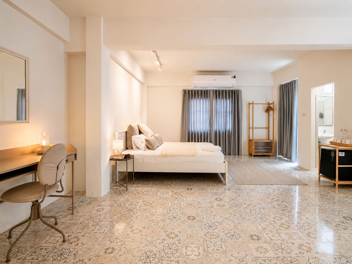 Una camera d'albergo con un letto, una scrivania, una sedia, un armadio e un bagno.
