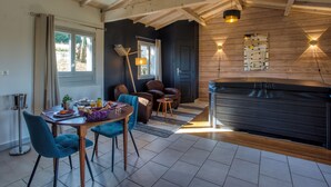 Une cuisine moderne avec un plafond en bois, un coin repas avec des chaises bleues et un jacuzzi intégré.