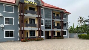 A multi-story building with balconies and a tiled courtyard. - Ekoara Apartments (Sekondi-Takoradi)