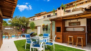 A patio with a pool, outdoor seating, and a barbecue area. - Bz34 Casa 150m da praia Piscina e Sauna (Buzios)