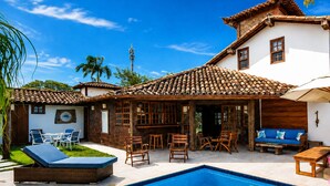A residential property with a swimming pool, outdoor furniture, and a patio area. - Bz34 Casa 150m da praia Piscina e Sauna (Buzios)