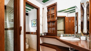 A bathroom with a wooden vanity, a large mirror, and a shower area. - Bz34 Casa 150m da praia Piscina e Sauna (Buzios)