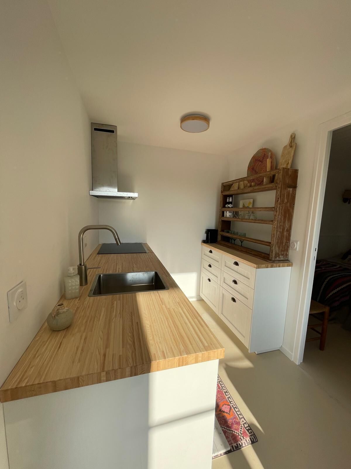 A compact kitchen with a wooden countertop, a stainless steel sink, and a built-in oven.