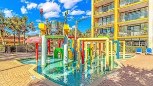 A children's play area with colorful structures and a pool.