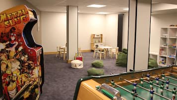 Relax in this cozy space with a foosball table, kitchenette, and comfortable seating areas.
