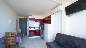 A compact living space with a dining area, kitchenette, and a sofa. - Clématite - Vue mer, plage à 100m, proche Espagne (Saint-Cyprien)