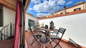 Eine Terrasse mit Tisch, Stühlen und einer Champagnerflasche.