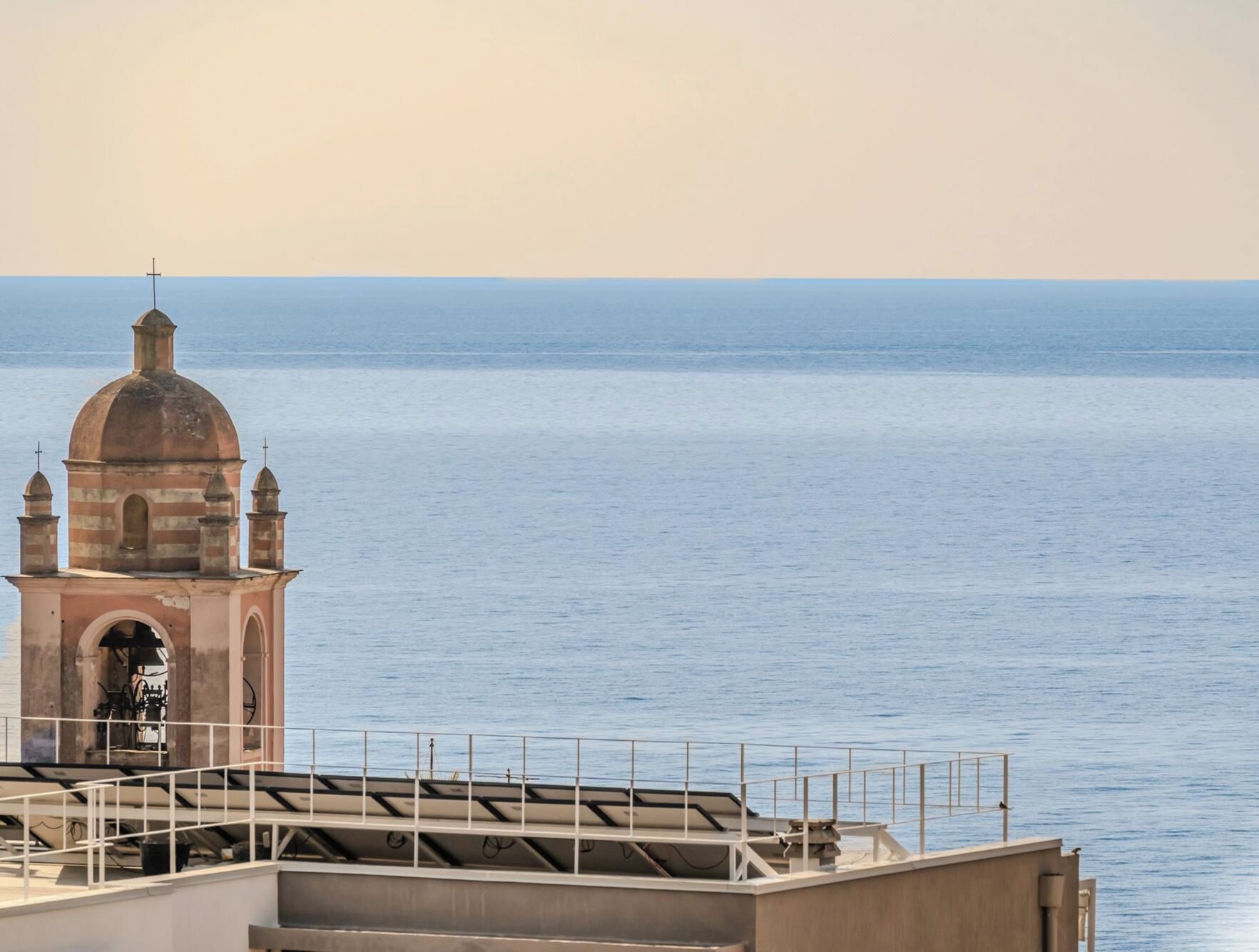 A coastal view with a church tower and a clear sky.