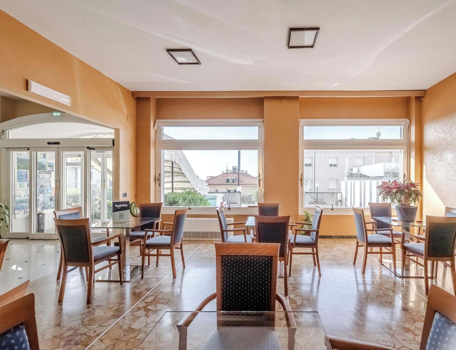A hotel lobby with a seating area, large windows, and a view of the cityscape.