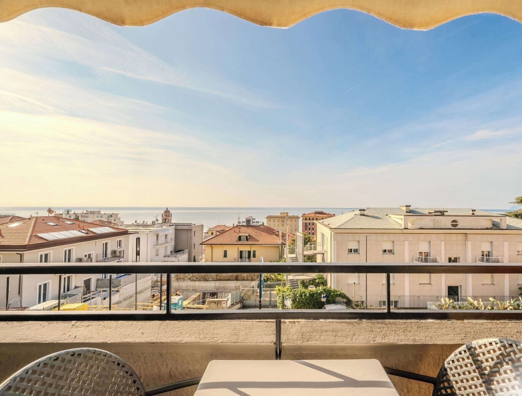 Ein Balkon mit Blick auf Gebäude und das Meer.