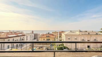 Ein Balkon mit Blick auf Gebäude und das Meer.